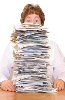 A woman behind a stack of papers.