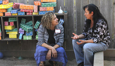 Two teachers discussing issues outside.