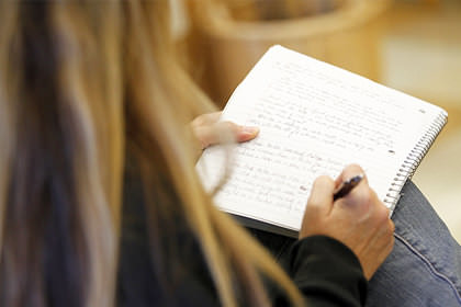 A close-up of a woman writing her journal.