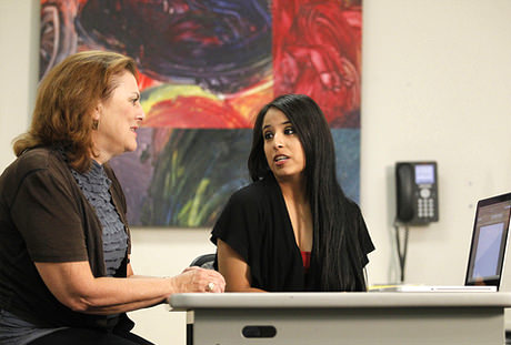 Two teachers talking at a table.